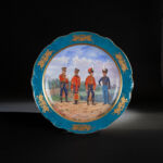 Russian porcelain plate, second half of the 19th century Light blue wall with thin, wide gold border, war emblems painted in gold. The dish depicts four soldiers in period uniforms
